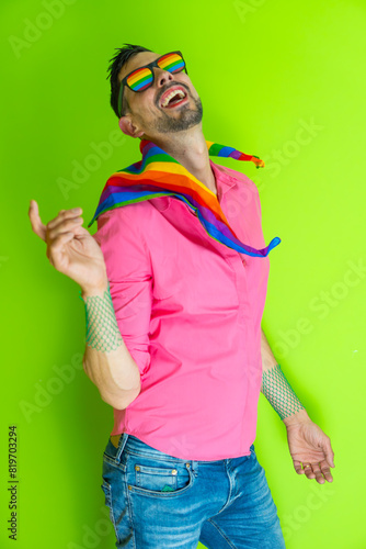 gay pride gay man dancing with glasses flag and rainbow LGBT scarf. concept happiness disinhibition and acceptance of homosexuality. photo