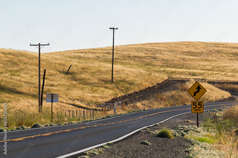 an beautiful, iconic and dreamy state road at the golden our CA-140 at catheys Valley, California. With a traffic sign shows 55 Miles per our speed limit and warning for curve