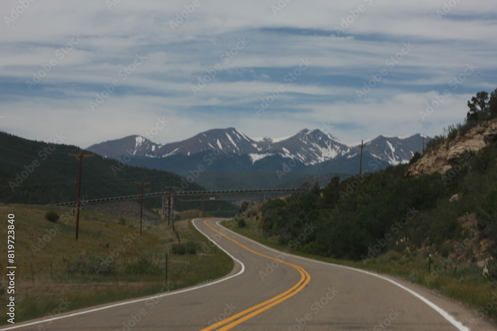 the road runs on two sides, near a hillside with mountains the road runs on two sides, near a hillside with mountains