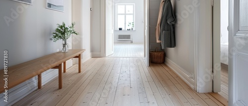 Minimalist hallway with light wooden floors  a single bench  and a coat rack  highlighting simplicity and functional design