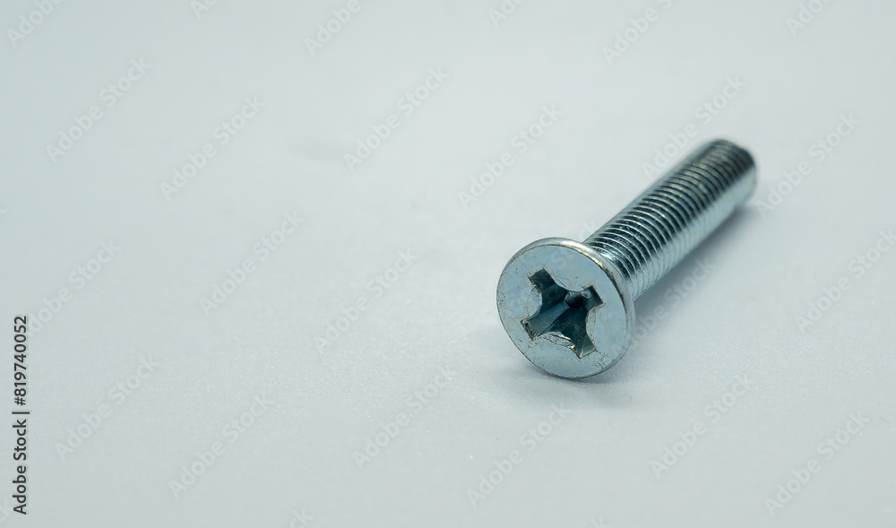Close-up of a lone screw resting on a white background Close-up of a lone screw resting on a white background