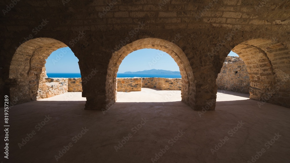 Fototapeta premium Empty arched structure overlooks the ocean on a sunny day