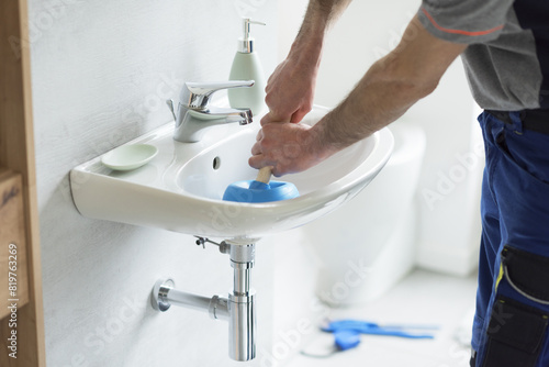 Repairman unclogging a bathroom sink photo