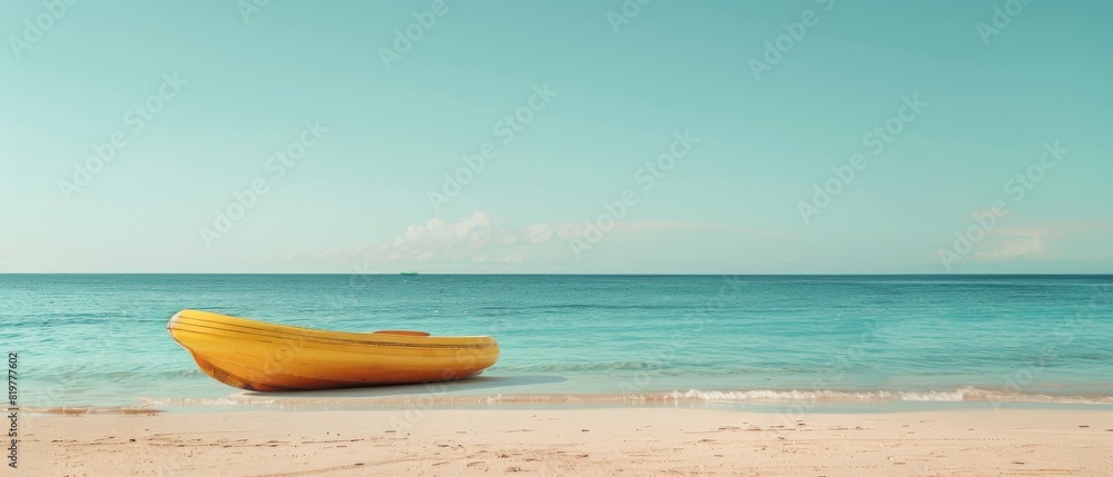 A yellow kayak is sitting on the beach next to the ocean A yellow kayak is sitting on the beach next to the ocean
