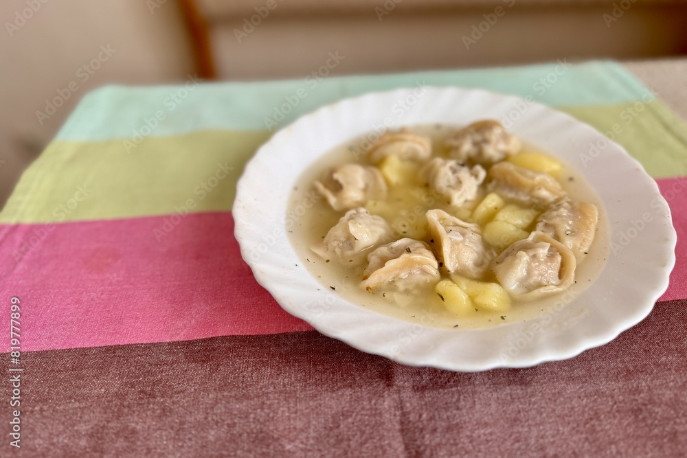 Delicious home dumplings from a white plate from a table in a restaurant. Close-up Delicious home dumplings from a white plate from a table in a restaurant. Close-up