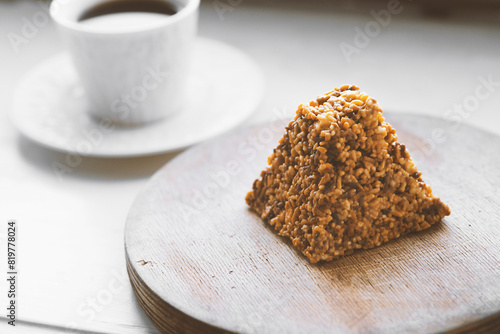 Cup of coffee and a piece of cake on a wooden board