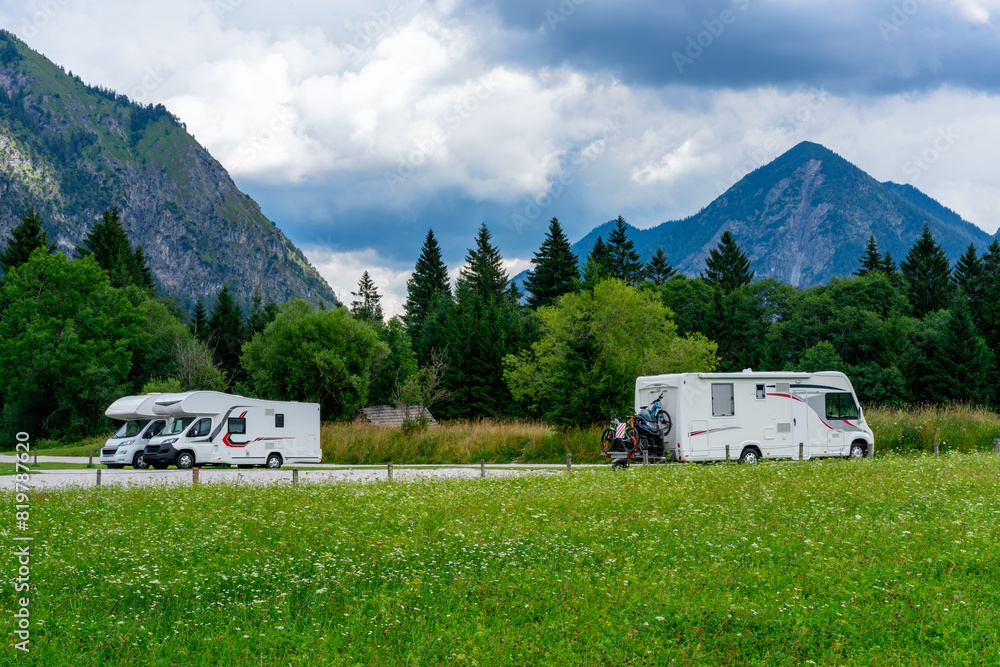 Motorhomes parked in the scenic Alps landscape Motorhomes parked in the scenic Alps landscape