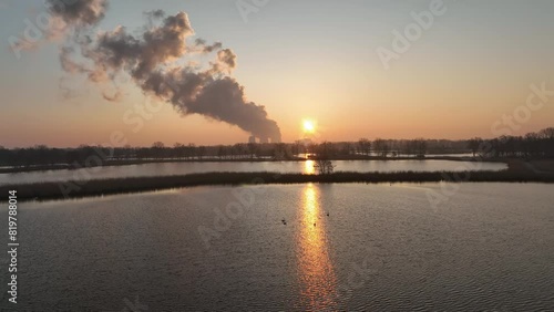 Drone view of geese swimming in flooded river in rural nature landscape at sunset time photo