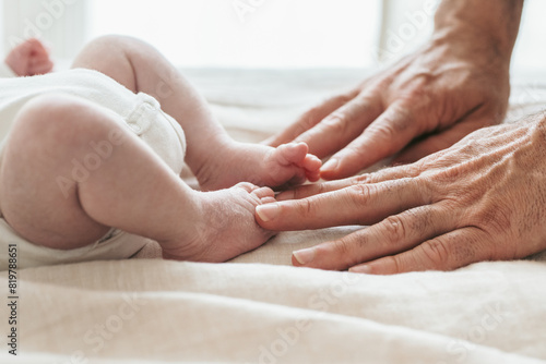 Gentle touch between a baby and adult hands photo