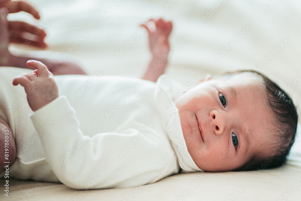 Serene newborn baby lying down in soft lighting Serene newborn baby lying down in soft lighting