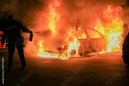 Police officer is seen putting out a fire, equipped with protective gear and a fire extinguisher