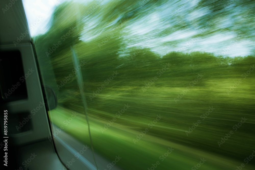 Scenic view of trees seen with a blur effect through the window of a moving vehicle Scenic view of trees seen with a blur effect through the window of a moving vehicle