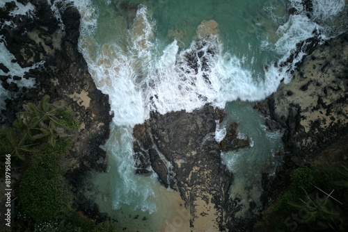 Aerial shot of a tranquil waterfall cascading down a rocky mountain terrain. photo