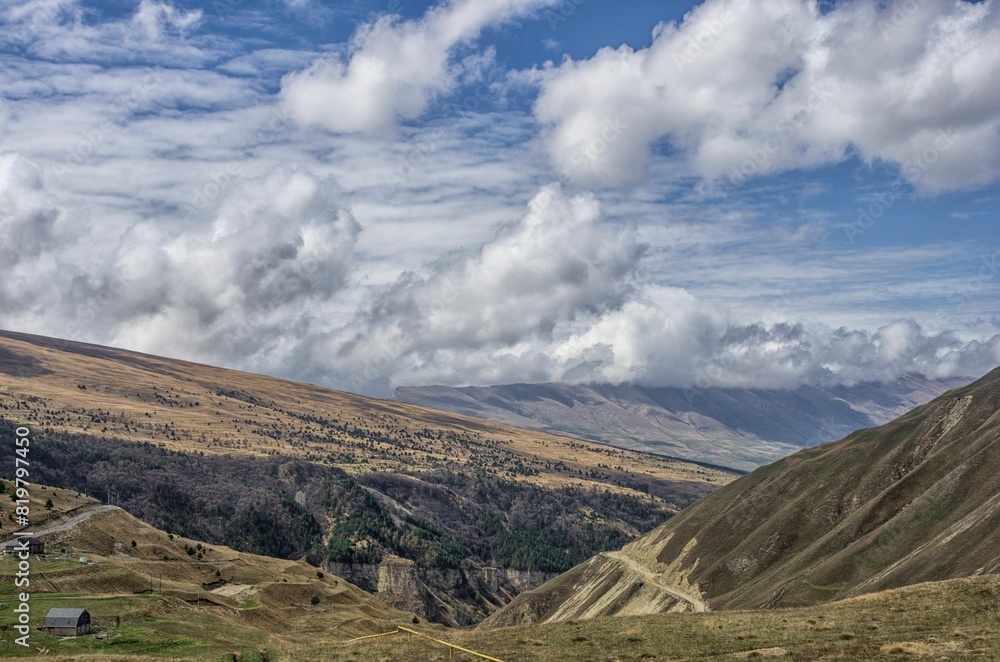 Scenic view of a mountainous landscape with rolling hills covered in clouds Scenic view of a mountainous landscape with rolling hills covered in clouds