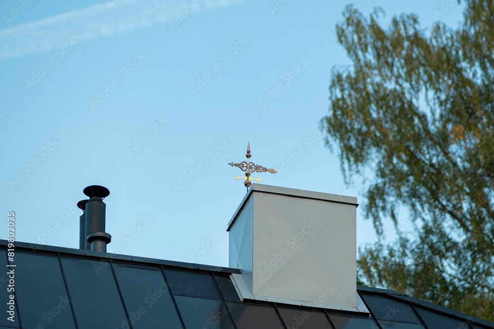 Antique vane perched atop a building against a backdrop of a clear blue sky Antique vane perched atop a building against a backdrop of a clear blue sky