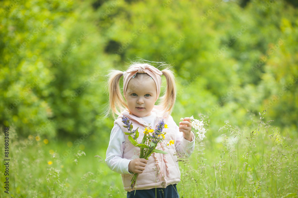 Cute little girl with bouquet of field flowers on the meadow in spring day. happy childhood Cute little girl with bouquet of field flowers on the meadow in spring day. happy childhood