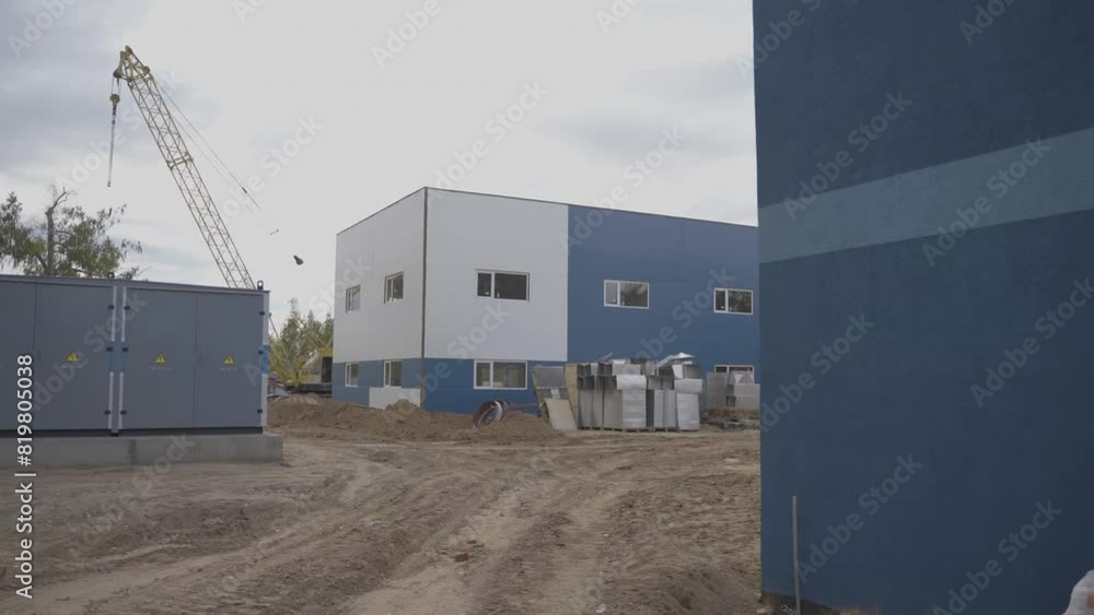 Cars construction equipment working in industrial area. Crane with dump truck work in factory near large factory building slow motion Cars construction equipment working in industrial area. Crane with dump truck work in factory near large factory building slow motion