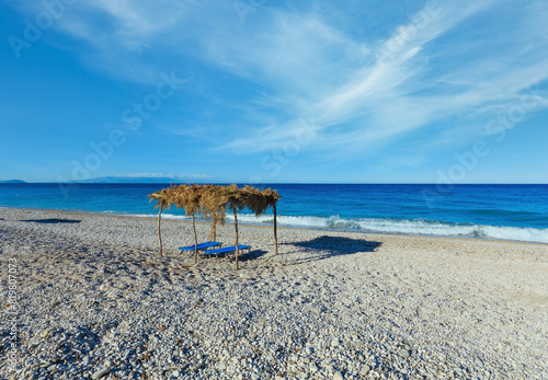 Summer morning beach with sunbeds and canopy (Albania).
