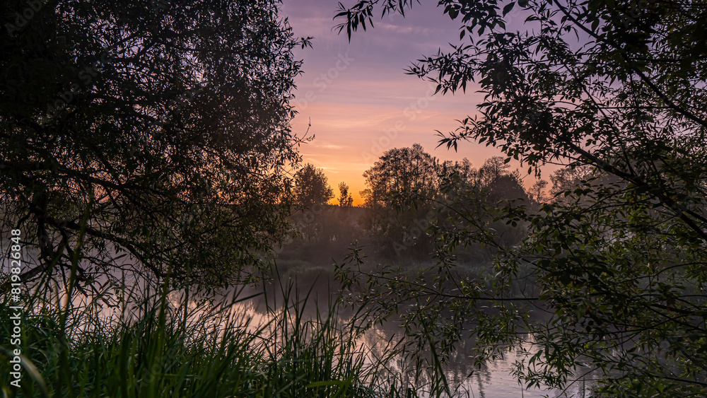 Obraz premium Sunrise over the Suprasl River at the boulevard in Suprasl.