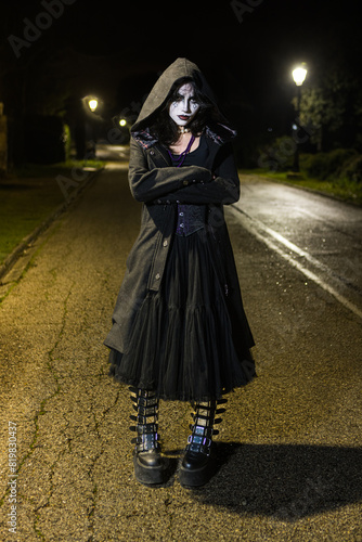 Mysterious Woman in Gothic Makeup on a Dark Street photo