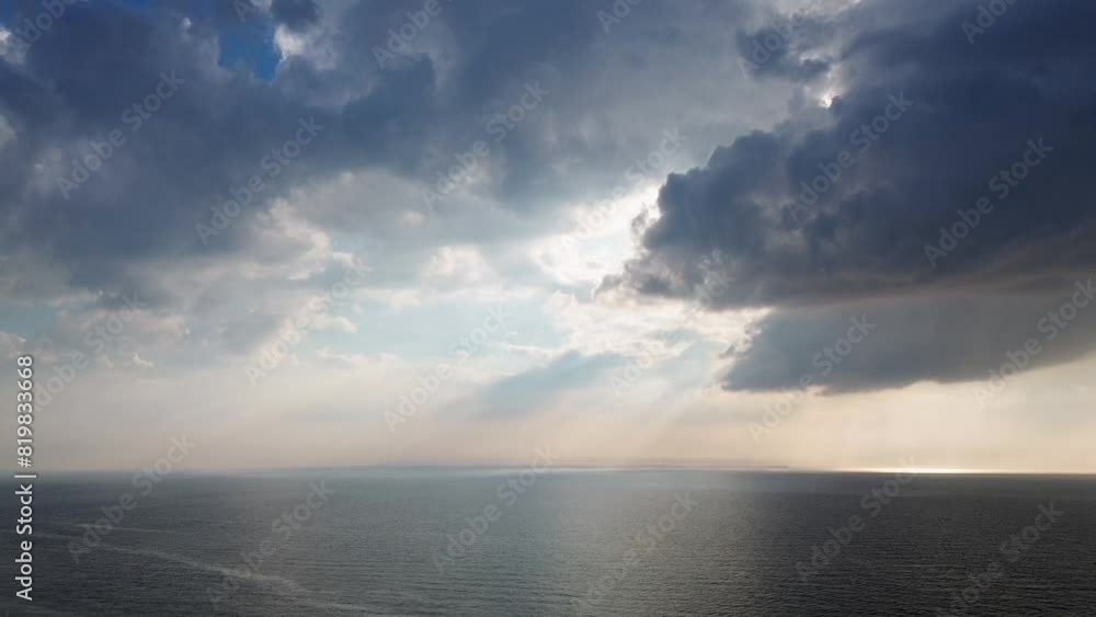 Beautiful sunset over the sea, ocean. Top view from a quadcopter. Beautiful flight. Ships and windmills on the horizon. The rays of the sun break through the clouds. Beautiful sunset over the sea, ocean. Top view from a quadcopter. Beautiful flight. Ships and windmills on the horizon. The rays of the sun break through the clouds.