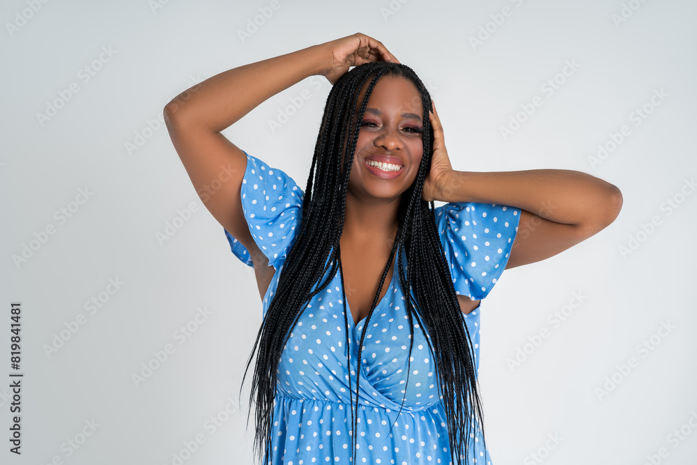 Fototapeta premium Happy plus size black model in blue dress, African woman with curvy figure and pigtailed hairstyle, afro braids