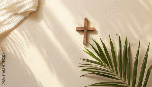 Wooden cross and palm leaf on beige background