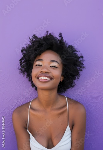 A portrait of a content and elegant woman showcases her beauty and grace against a vibrant purple backdrop, her cheerful expression radiating joy. 