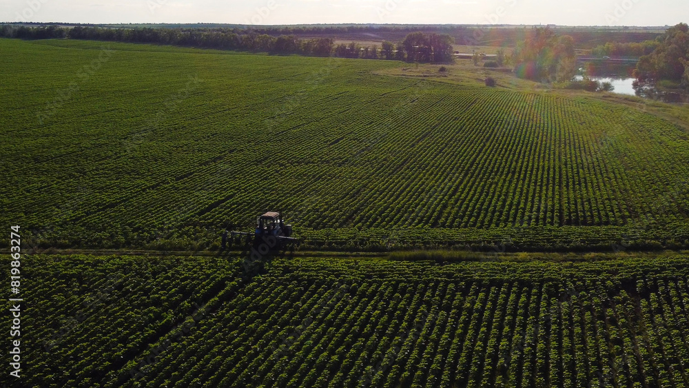 Obraz premium The tractor stands in a green field at sunset