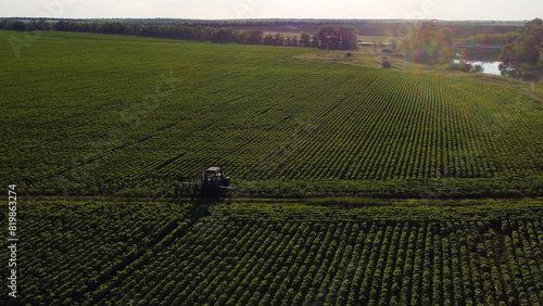 The tractor stands in a green field at sunset