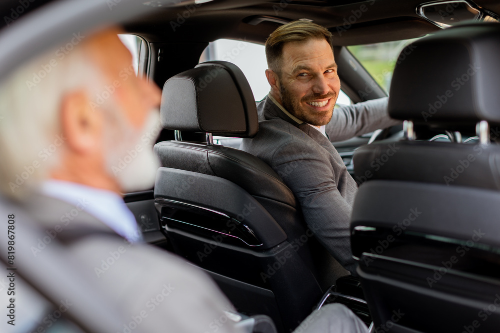 Businessmen sharing a laugh during morning commute in a car Businessmen sharing a laugh during morning commute in a car