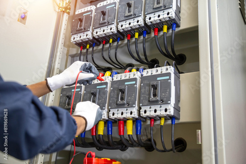 Electricity and electrical maintenance service, Engineer hand holding AC voltmeter checking electric current voltage at circuit breaker terminal and cable . 