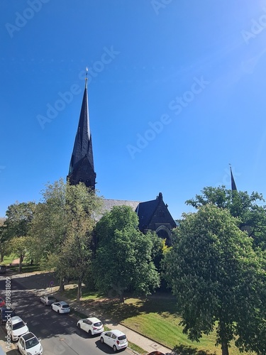 Sicht auf die Straße mit Autos, einem Park und den Umrissen der historischen, alten Himmelfahrtskirche in Altleuben, Dresden (Sachsen, Deutschland) photo