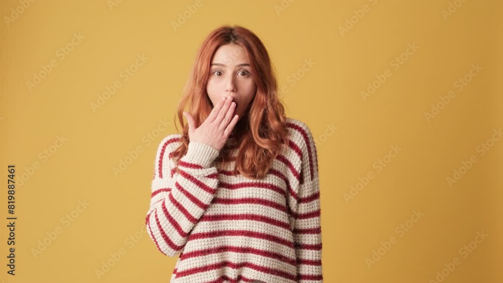 Surprised girl looks to side in studio on yellow background Surprised girl looks to side in studio on yellow background