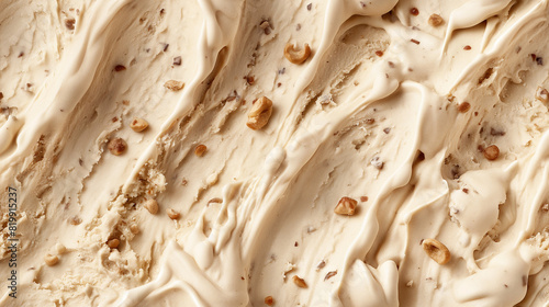 top view of hazelnut praline ice cream surface, a closeup of the hazelnut praline ice cream texture, featuring its creamy base with pieces of praline and hazelnut swirls