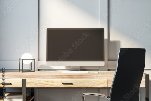 A modern computer on a wooden desk with a decorative object, against a grey background in a light-filled office space, depicting a professional workspace concept. 3D Rendering