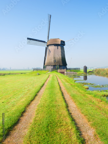 View of an old windmill, Holland. The road leading to the windmill. Agriculture. Historical buildings. View of landscapes in the Netherlands. Nature in the morning. © biletskiyevgeniy.com