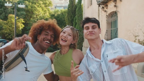 Three friends taking pictures together on the street on a sunny summer day