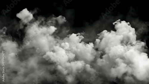A cloud of smoke is billowing out of a black background. The smoke is thick and hazy, creating a sense of mystery and unease. Feeling of danger or impending doom photo