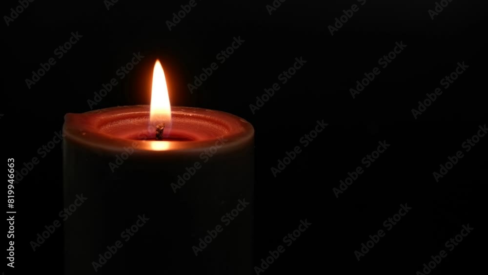 Black candle burning and melting on black background close-up. Copy space for text. Black candle burning and melting on black background close-up. Copy space for text.