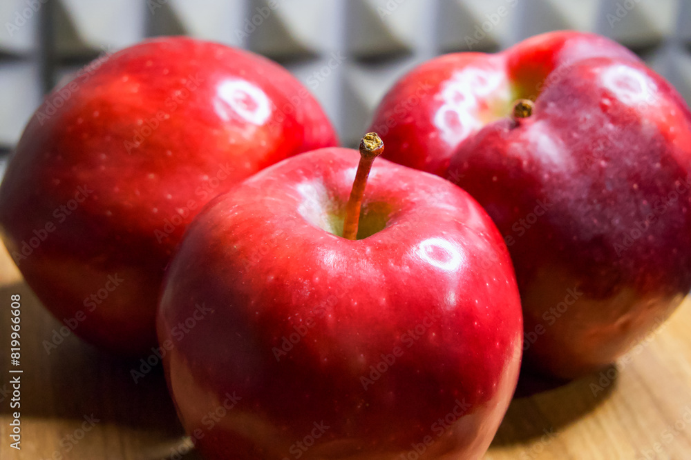 Glossy Apples. Apples with a shiny finish against a dark patterned background.
