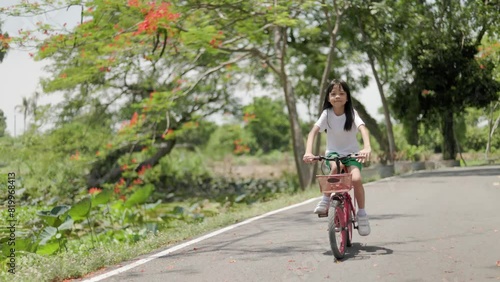 Wallpaper Mural Handheld video Portrait of a Thai Asian kid girl, aged 8 to 10 years, learning and exercising on a bicycle in an outdoor park on vacation. happily and have fun She is a strong and intelligent girl. Torontodigital.ca