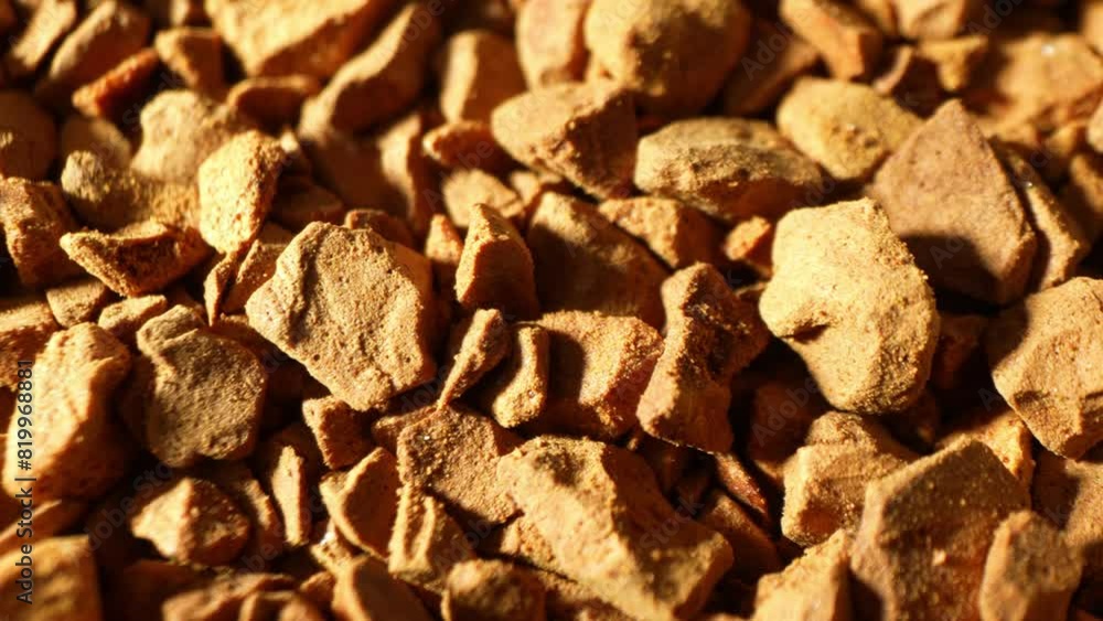Close-up reveals freeze-dried coffee granules: their varied forms and rich golden tones under soft illumination, accentuating their dry, rough texture, evoking a sensory journey.
Close-up reveals freeze-dried coffee granules: their varied forms and rich golden tones under soft illumination, accentuating their dry, rough texture, evoking a sensory journey.