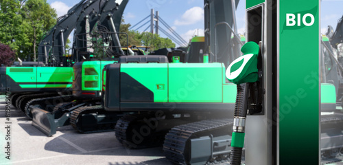 Biofuel filling station on a background of green construction machines. Decarbonization of heavy industrial vehicles