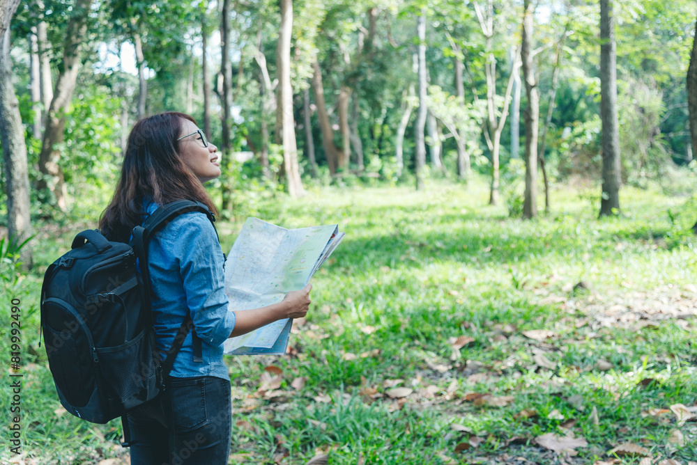 Women outdoor travel lifestyle Asian young woman traveler backpack looking map in green nature park. Female tourist backpacker holding brochure on vacation. Happy Tourism trip women journey walk park Women outdoor travel lifestyle Asian young woman traveler backpack looking map in green nature park. Female tourist backpacker holding brochure on vacation. Happy Tourism trip women journey walk park