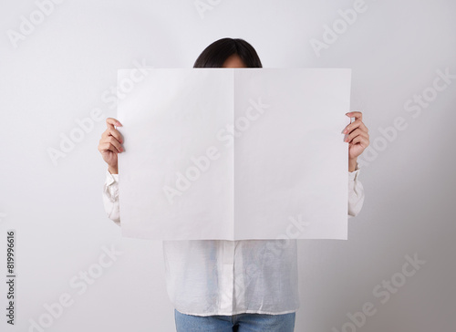 Woman reading mockup of blank newspapers to add your own news isolated on white background.