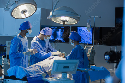 Surgeons team working with Monitoring of patient in surgical operating room. The doctors and nurses brainstorm power assisted surgery. A team of professional doctors perform surgery in a hospital