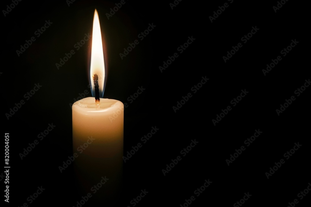 A white candle burning in the dark background ，The concept of remembrance and reflection during a memorial day.