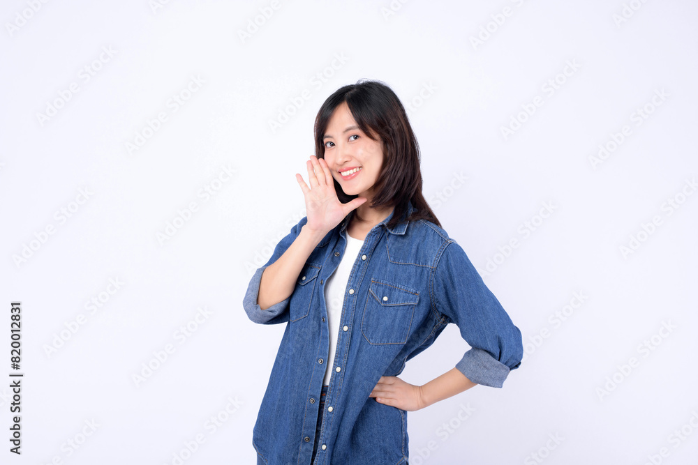 Asian woman wearing denim jean is posing with a shouting gesture against a white background. Asian woman wearing denim jean is posing with a shouting gesture against a white background.