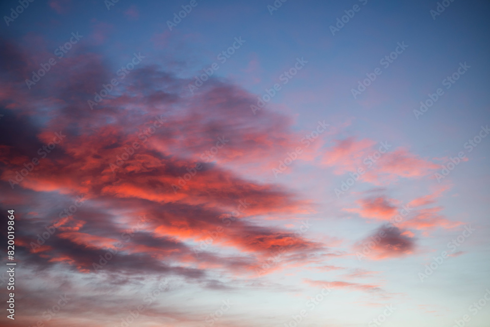 Obraz premium Sunset, red clouds on the background of the blue sky